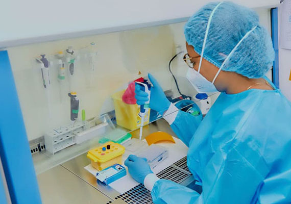 In a laboratory, under a fume hood, a laboratory technician handles samples.