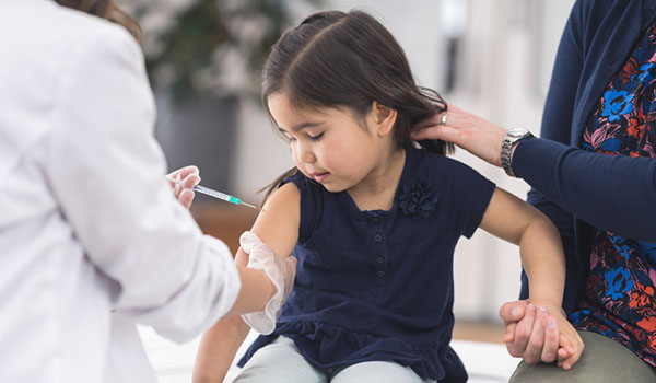 Young ethnic girl at the doctor's office getting a shot