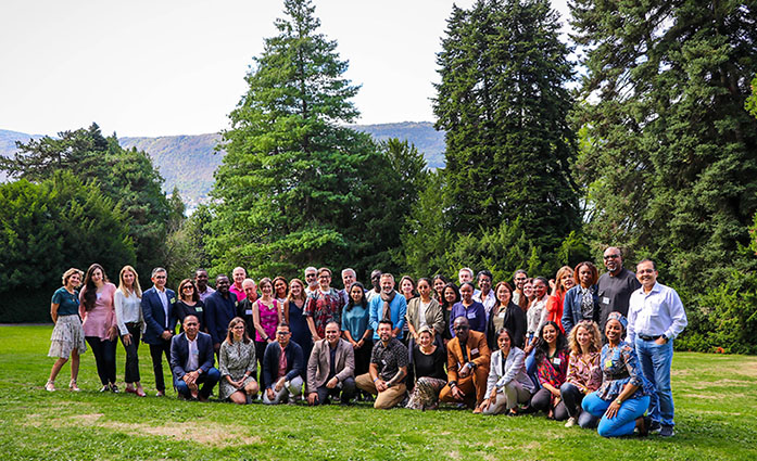 Participants in a park, trees in the background and Lake Annecy behind them.