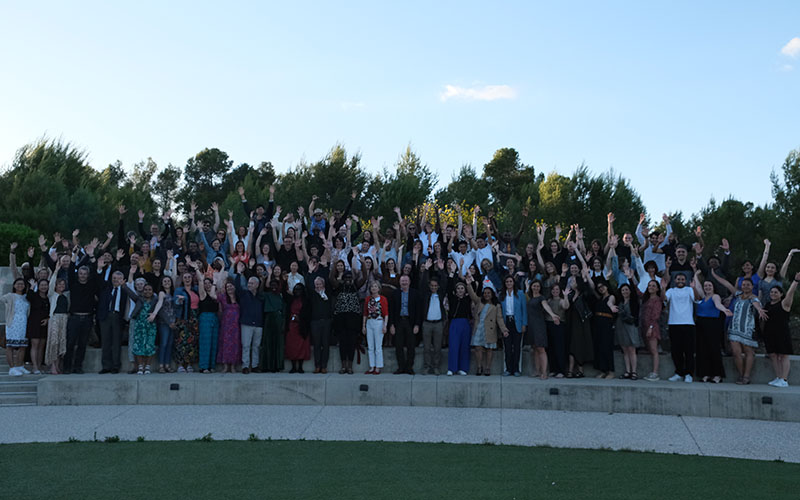 All members of the Mérieux Foundation stand on a platform outside.