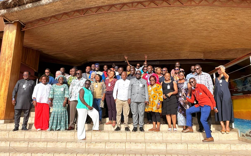 Un groupe de participants d'Afro-ACDx se tiennent debout sur des marches, à l'entrée d'un bâtimente.