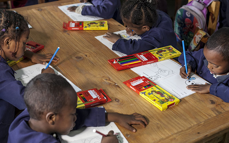 Children drawing around a table with colored pencils in Madagascar 