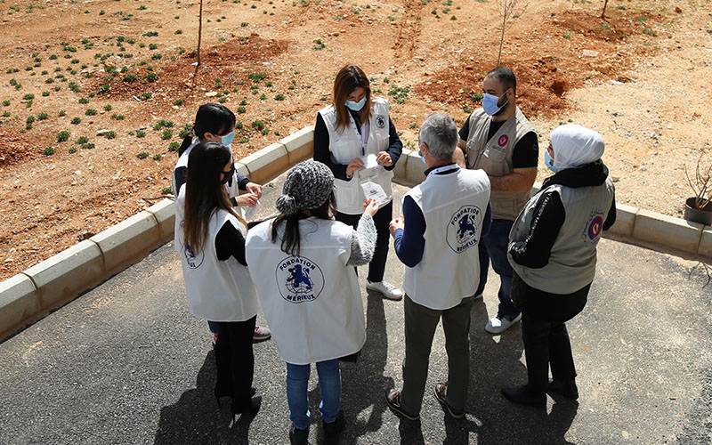 Staff in white vests gathered outside the Douris Health Center in Lebanon