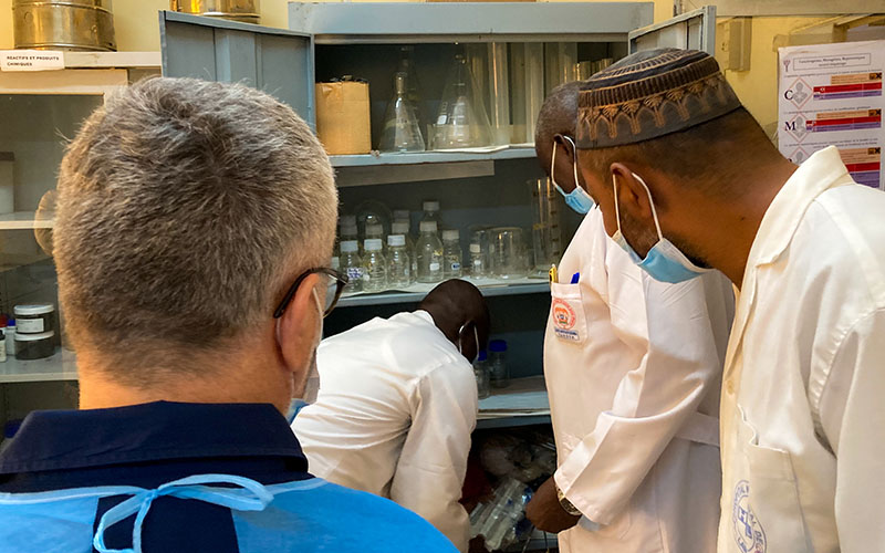 Healthcare professionals in white coats handling laboratory equipment in Niger