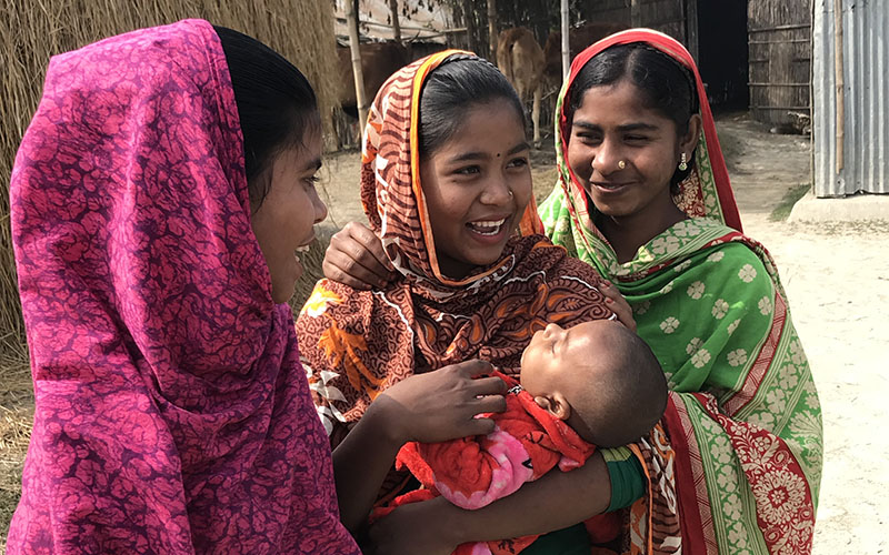Trois femmes en tenue traditionnelle tenant un enfant