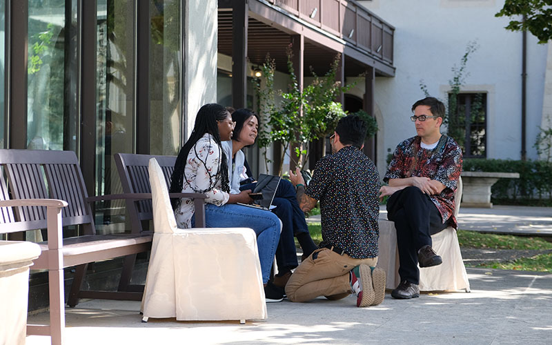 Four participants of the ACDx course discussing in the courtyard of Les Pensières Center for Global Health